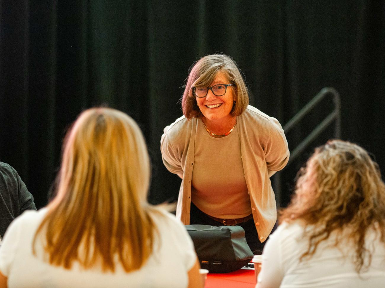 Faculty member talks with a group during conference