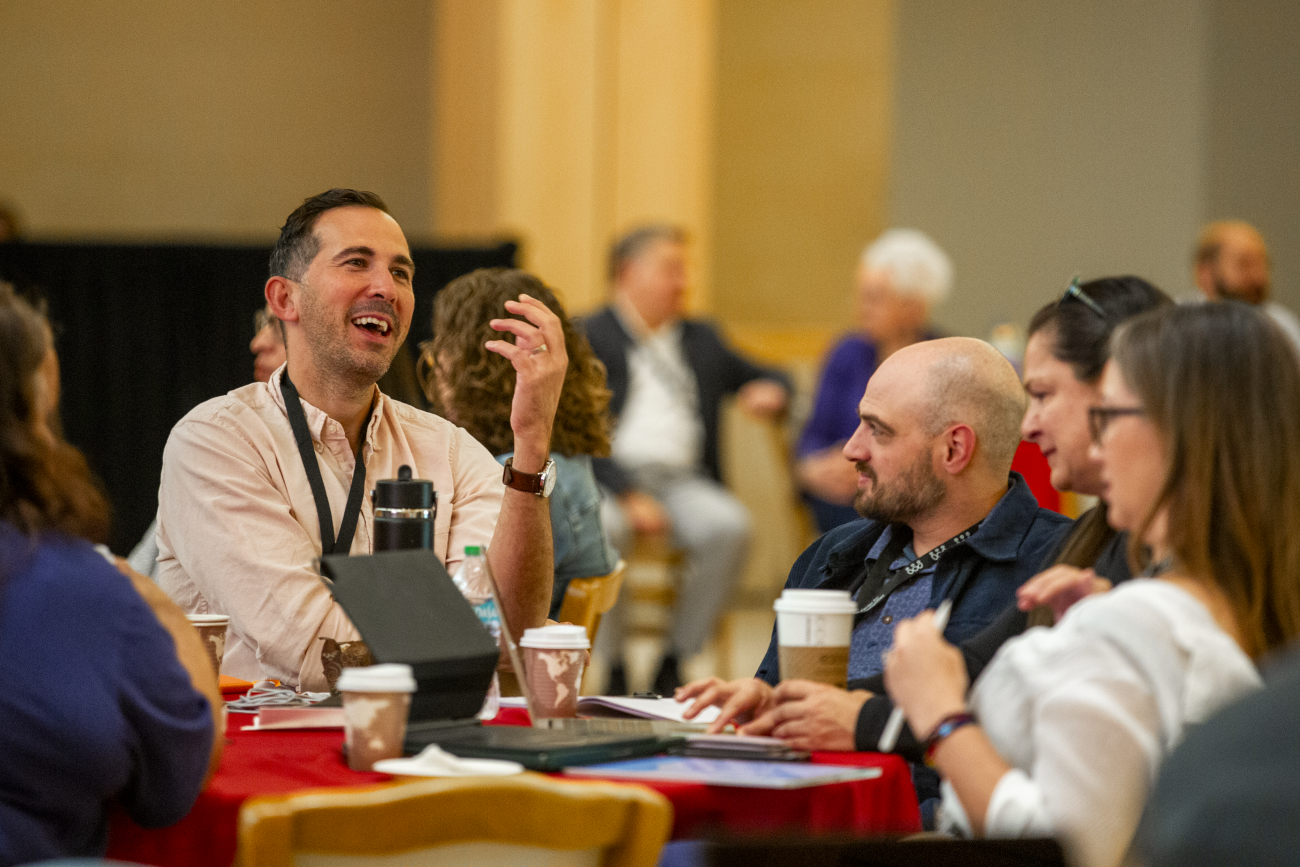 Attendees talk with one another at the annual collaborative conference