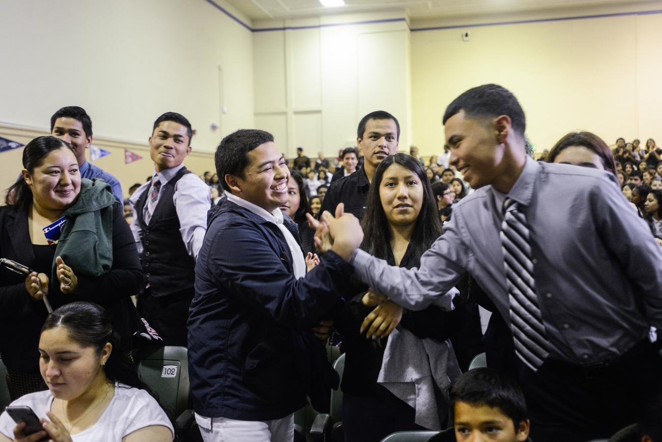 School leader high fives student during assembly