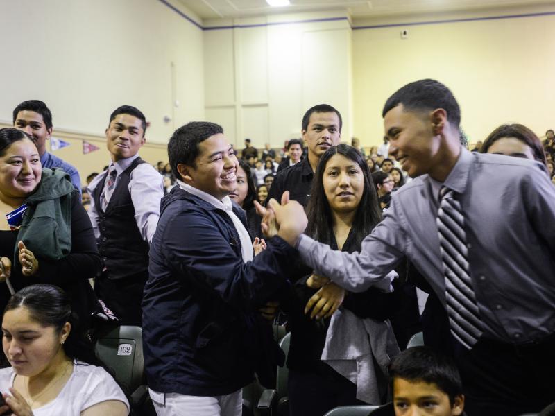 School leader high fives student during assembly