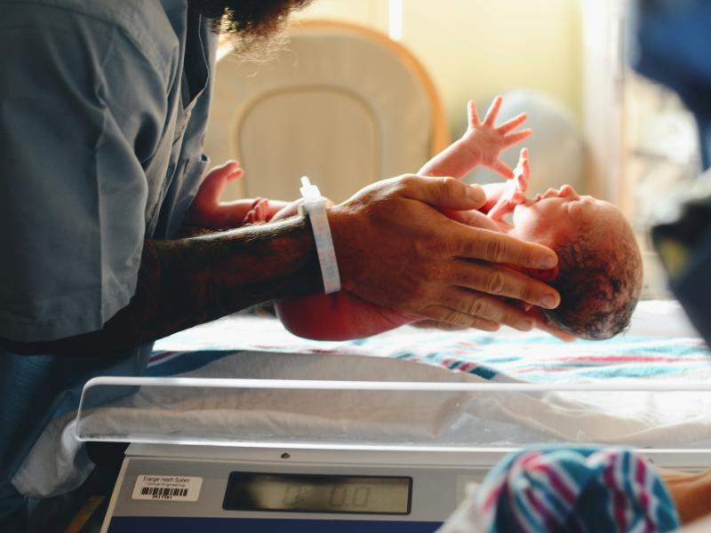 Nurse holds newborn in hospital